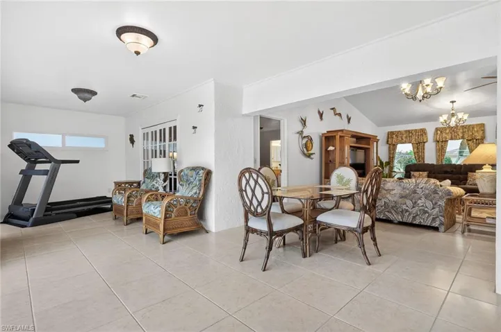 Dining space featuring hanging lights, light tile patterned floors, and vaulted ceiling