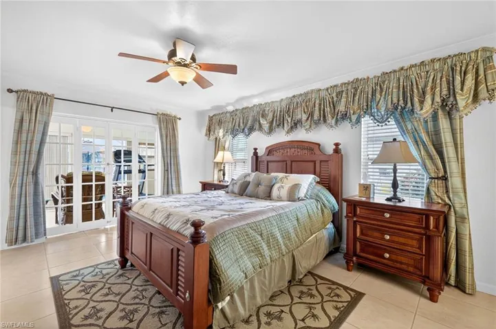 Bedroom with light tile patterned floors, a ceiling fan, and access to exterior