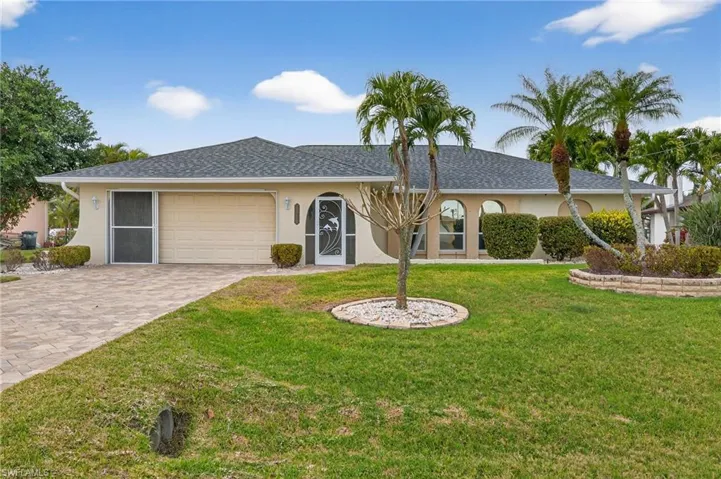 Ranch-style house featuring stucco siding, a garage, decorative driveway, a front yard, and roof with shingles