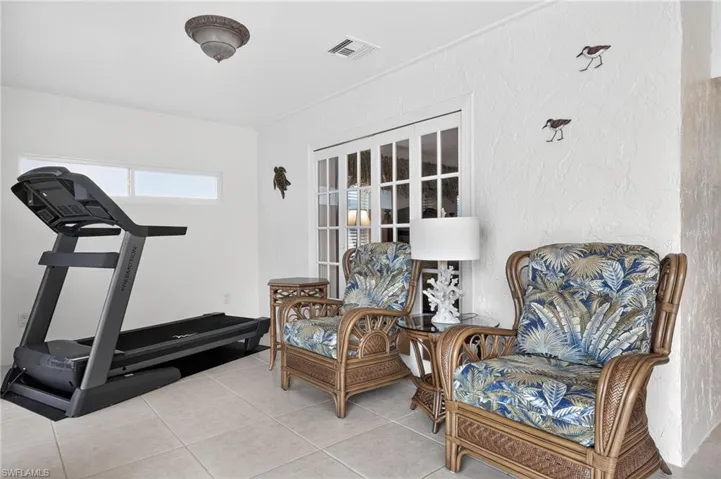 Sitting room featuring a textured wall and light tile patterned floors