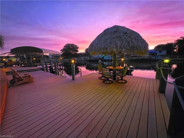 Wooden terrace featuring a water view, a boat dock, and boat lift