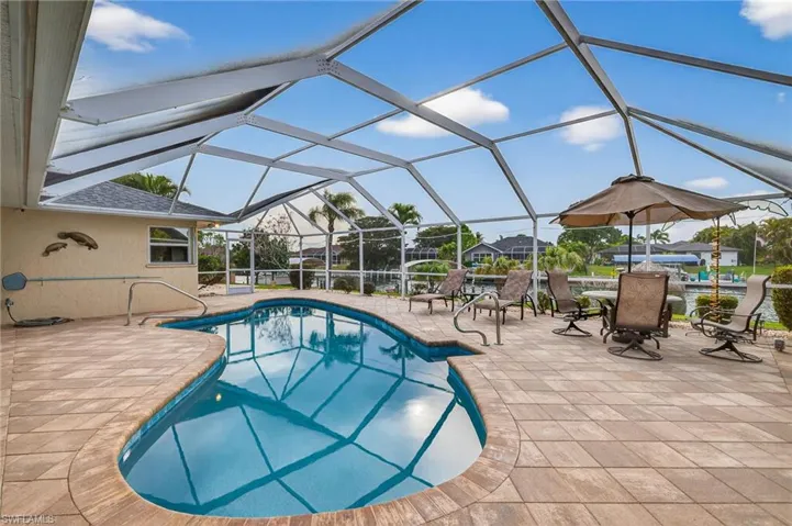Outdoor pool featuring a sunroom, a lanai, a patio, and outdoor dining space