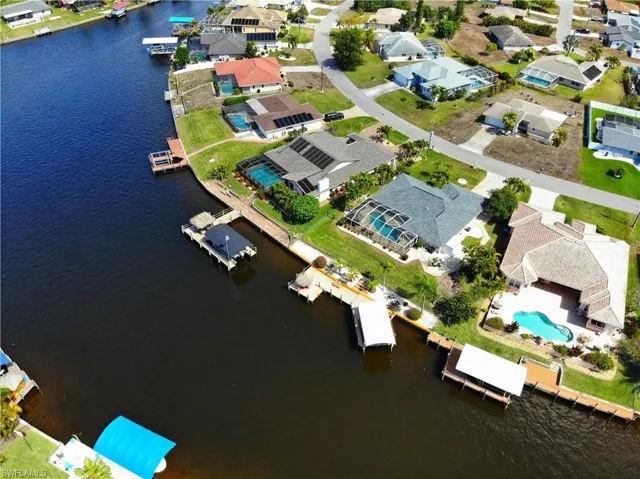 Aerial view of property and surrounding area with a nearby body of water and nearby suburban area