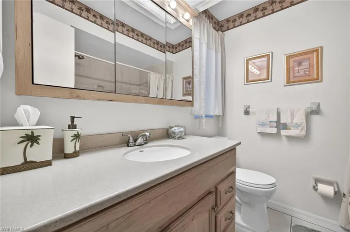 Bathroom featuring vanity, curtained shower, and light tile patterned flooring