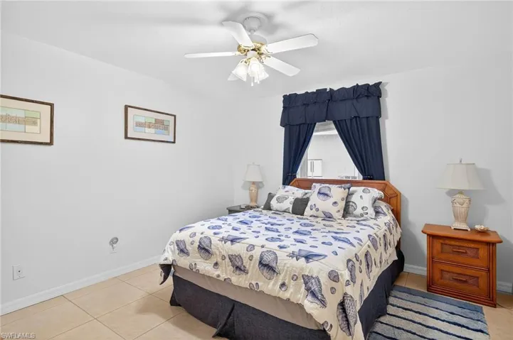 Bedroom with light tile patterned floors and a ceiling fan