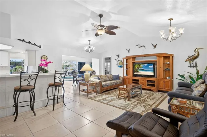 Living room with hanging lights, light tile patterned floors, and a ceiling fan
