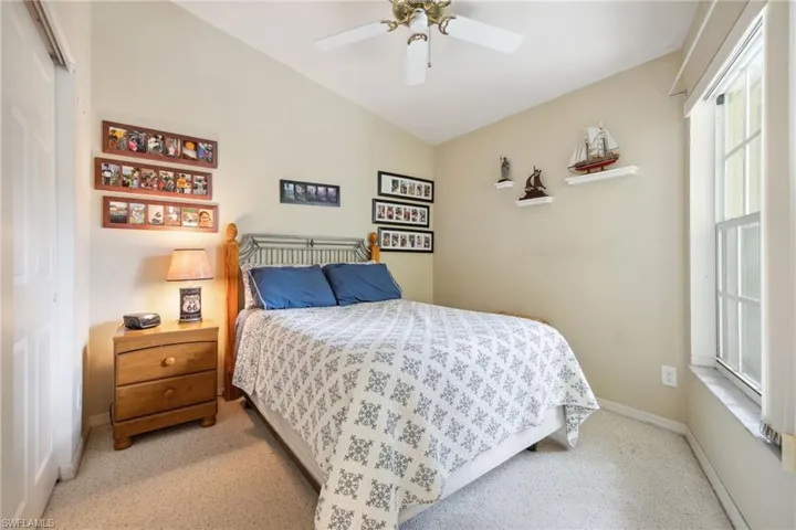 Bedroom featuring ceiling fan, baseboards, and vaulted ceiling