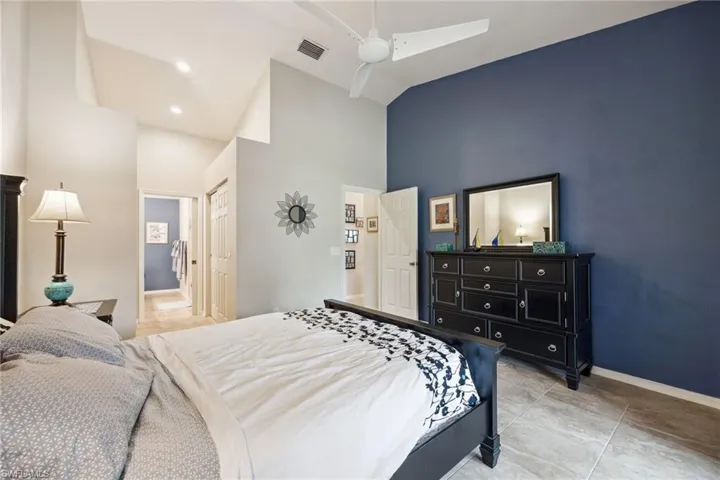 Bedroom featuring baseboards, recessed lighting, a ceiling fan, visible vents, and high vaulted ceiling