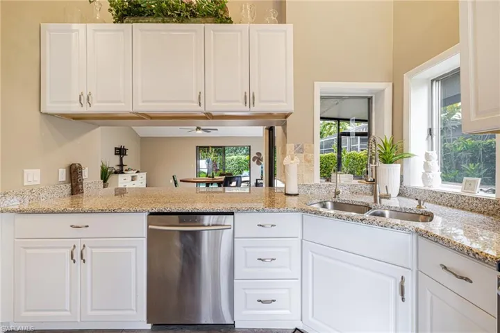 Kitchen featuring white cabinetry, granite countertops, and a stainless steel dishwasher