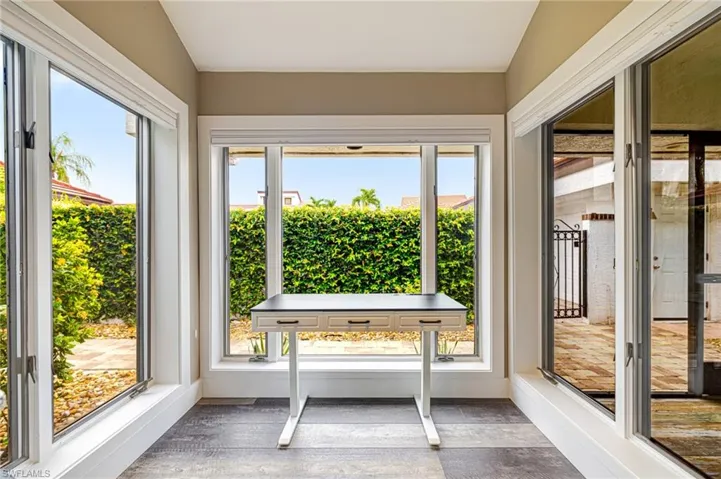 Windowed alcove featuring extensive glazing, light-toned wall paint, and dark-toned tile flooring