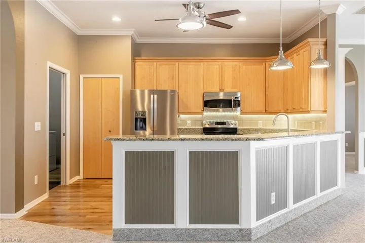 Kitchen featuring light  wood-style flooring, Granite countertops, light brown wood cabinetry, tasteful backsplash, stainless steel appliances
