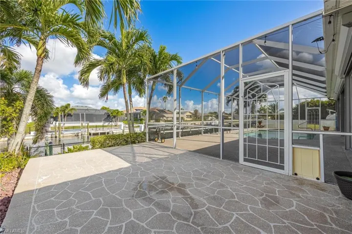 Expanded patio area outside pool enclosure with doggie door.