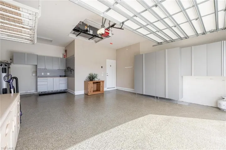 Garage with Epoxy floor & custom built in cabinets for storage and work bench area