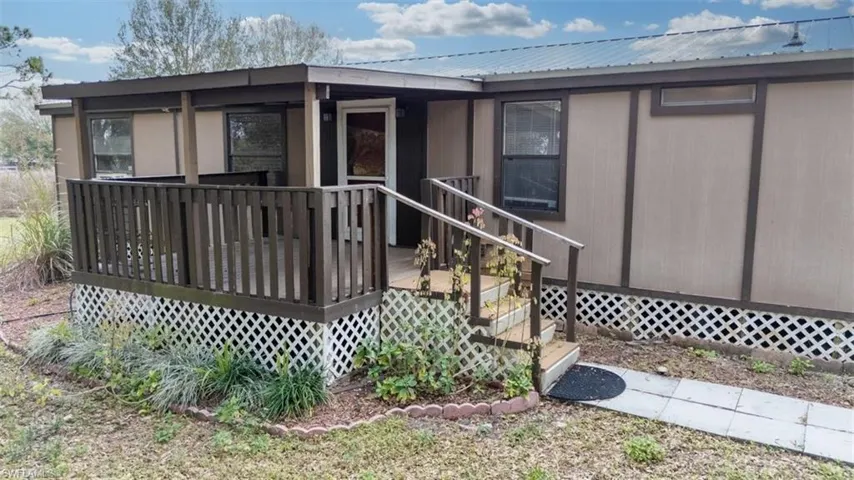 Rear view of house with a metal roof and a deck