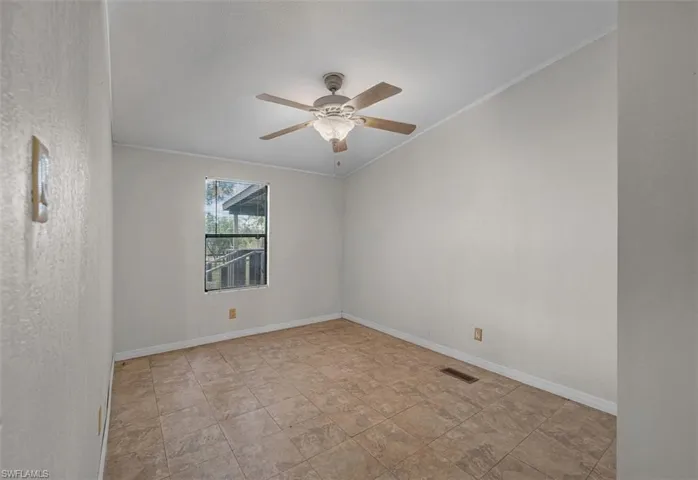 Unfurnished room featuring crown molding, ceiling fan, and stone finish floors