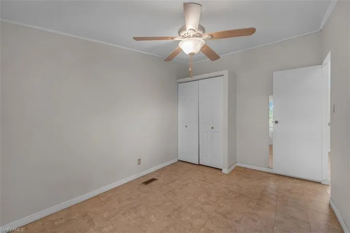 Unfurnished bedroom with a ceiling fan, ornamental molding, and a closet