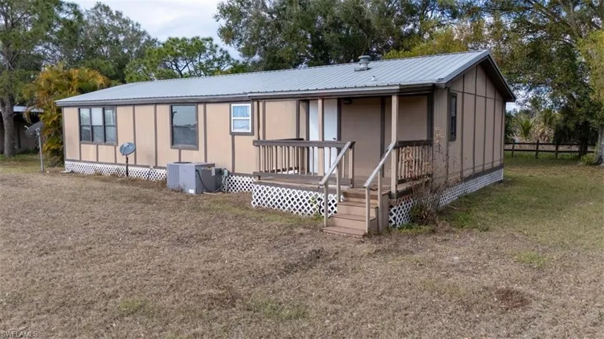 Rear view of property featuring a wooden deck and a metal roof