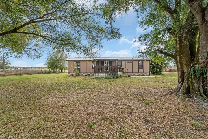 Rear view of property with a yard and a deck