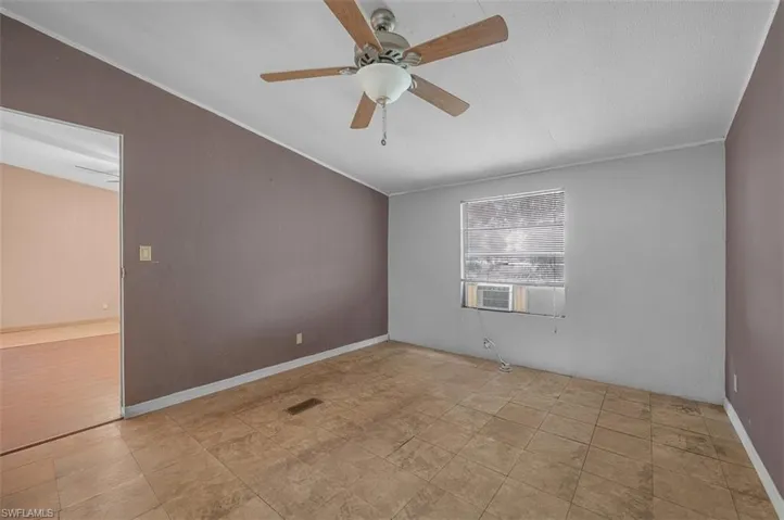Unfurnished room with lofted ceiling, ceiling fan, and ornamental molding