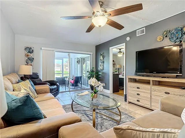Living room featuring light tile patterned floors and a ceiling fan