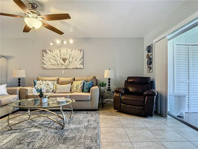 Living room featuring light tile patterned flooring and ceiling fan
