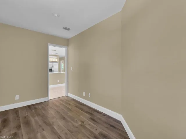 Unfurnished room featuring baseboards, visible vents, and wood finished floors