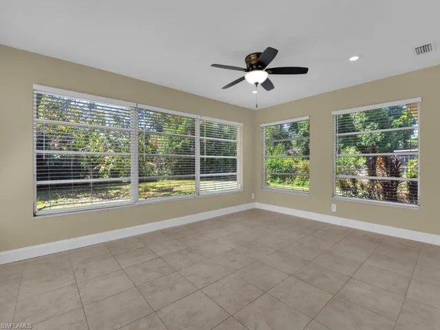 Unfurnished sunroom with recessed lighting, plenty of natural light, baseboards, and visible vents
