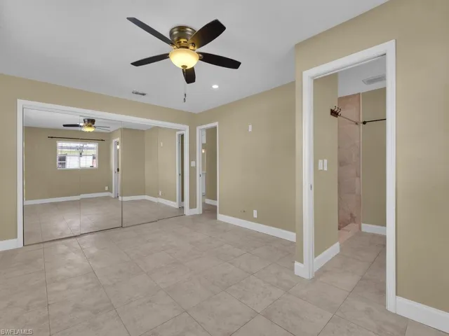 Unfurnished bedroom featuring light tile patterned floors, baseboards, ceiling fan, and visible vents