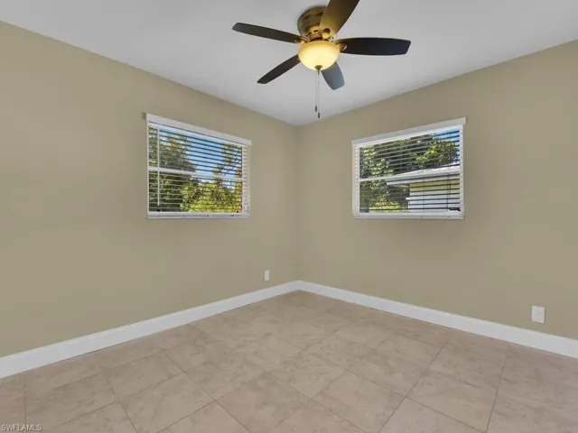 Unfurnished room with baseboards and ceiling fan