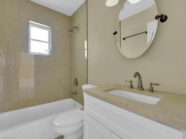 Full bath with toilet, vanity, and shower / washtub combination