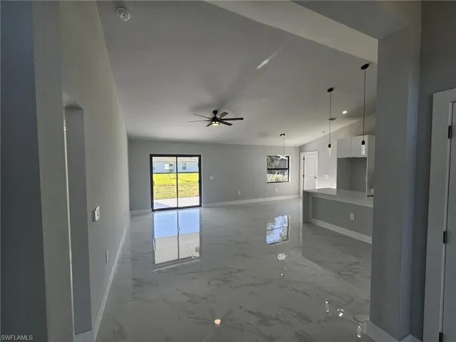 Unfurnished living room featuring ceiling fan