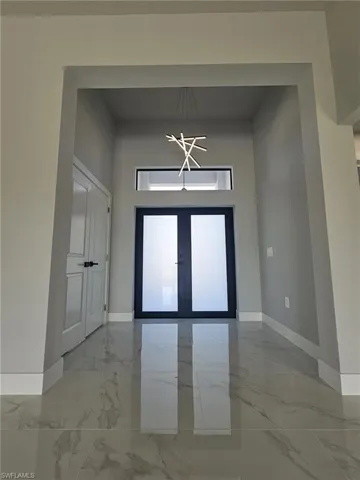 Entrance foyer with a high ceiling and french doors