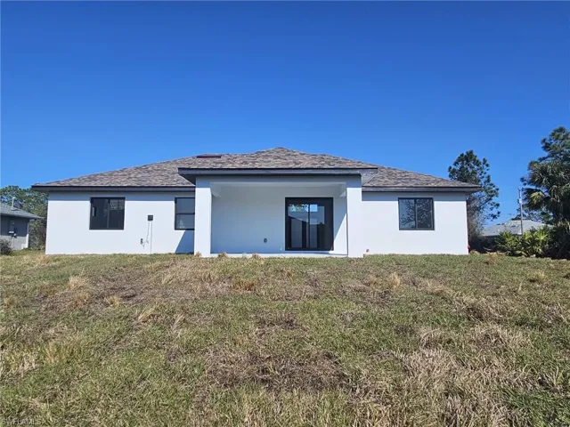 Rear view of house with a lawn