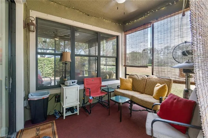 Sunroom featuring carpet floors, an outdoor living space, and a ceiling fan