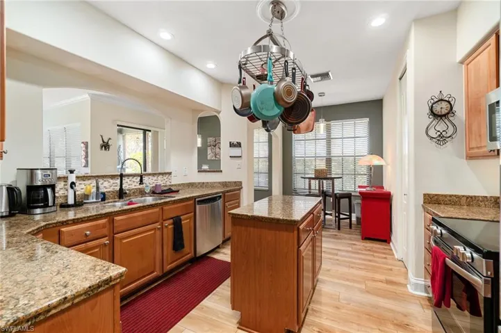 Kitchen featuring stainless steel appliances, visible vents, a sink, light wood-type flooring, and a kitchen island