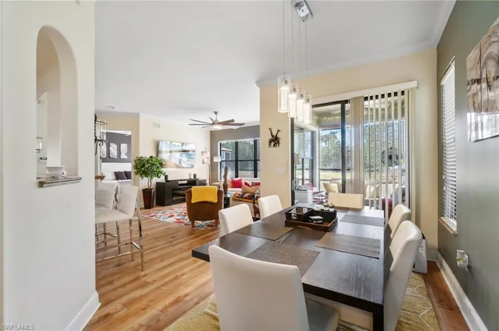 Dining room with wood finished floors, ceiling fan, and ornamental molding
