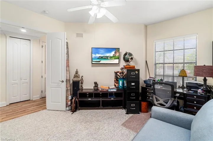 Office with wood finished floors, a ceiling fan, visible vents, and carpet flooring
