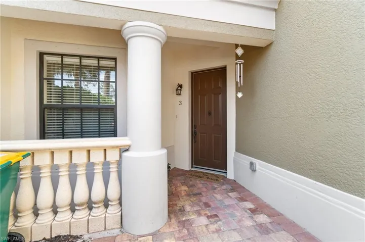 View of exterior entry featuring covered porch and stucco siding
