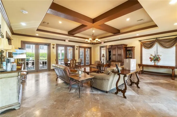 Living room with an inviting chandelier, visible vents, ornamental molding, and french doors
