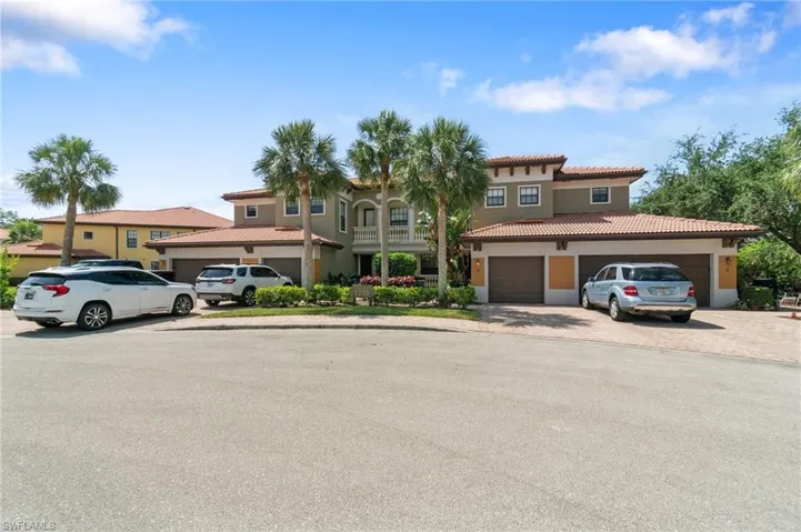 View of front of home with stucco siding, a tile roof, and driveway