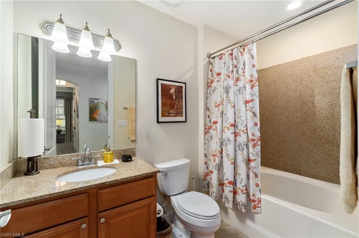Bathroom featuring toilet, crown molding, vanity, and shower / tub combo with curtain