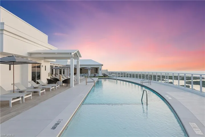 Pool at dusk featuring a community pool and a patio