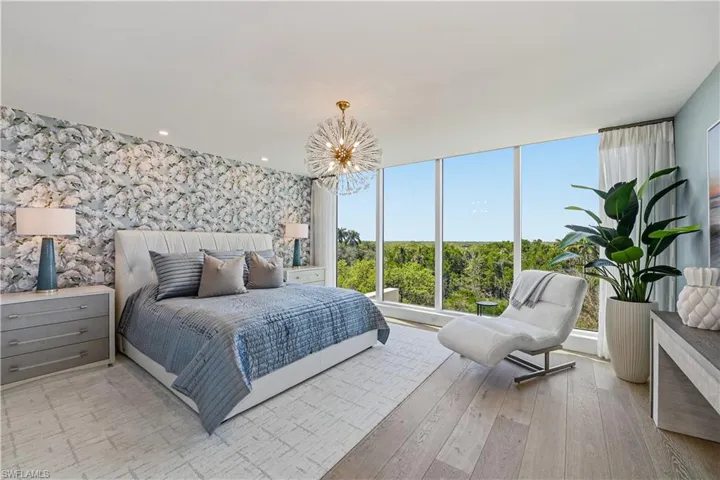 Bedroom with a chandelier, light wood-style flooring, and wallpapered walls