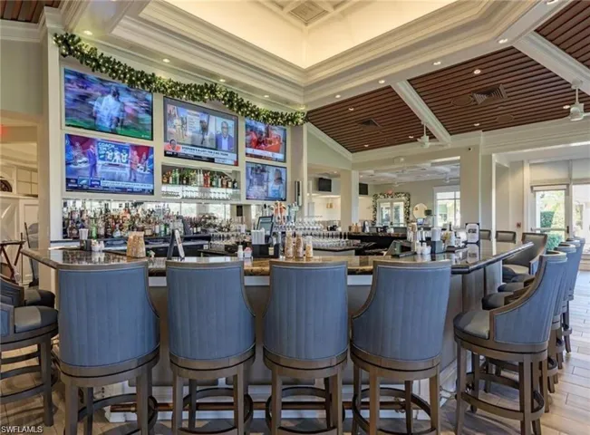 Bar with ornamental molding, dark stone countertops, cooling unit, and recessed lighting