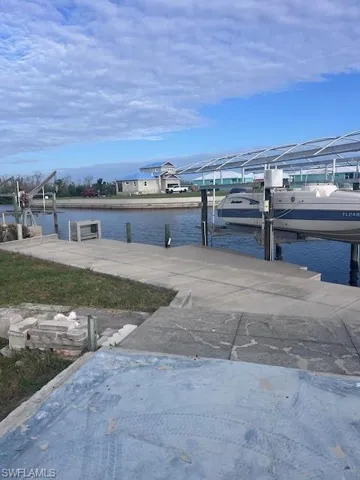 Dock area featuring boat lift and a water view