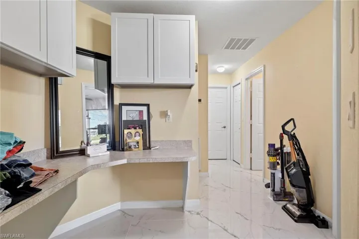 Hallway featuring light-toned walls and polished tile flooring