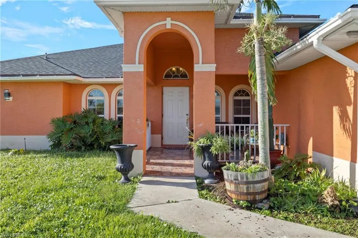 Mediterranean-inspired exterior with an arched entry, a covered front porch, and decorative arched windows