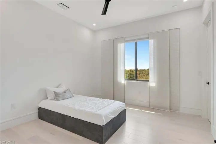 Bedroom featuring light wood-style flooring, a ceiling fan, visible vents, and recessed lighting