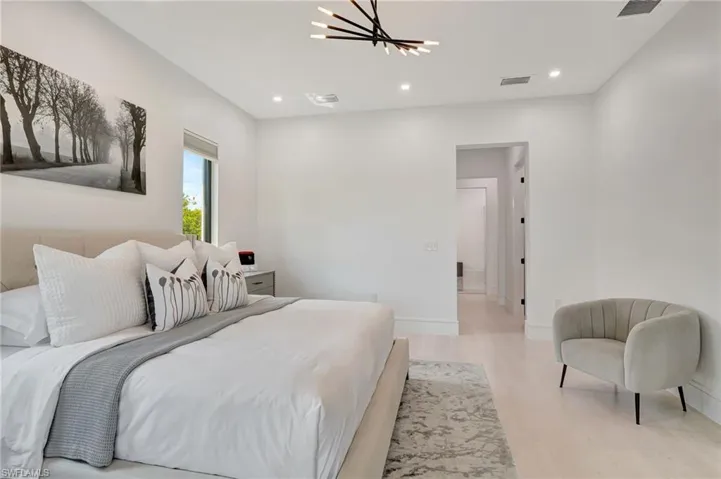Bedroom featuring visible vents, baseboards, a notable chandelier, recessed lighting, and wood finished floors
