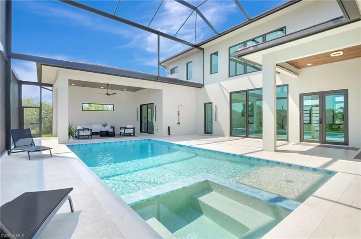 View of pool with a ceiling fan, a patio area, a lanai, an outdoor hangout area, and a pool with connected hot tub